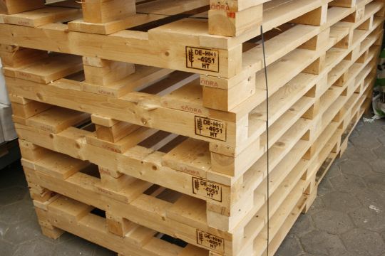 Übereinandergestapelte Holzpaletten für die Weiterverarbeitung in den Werkstätten.