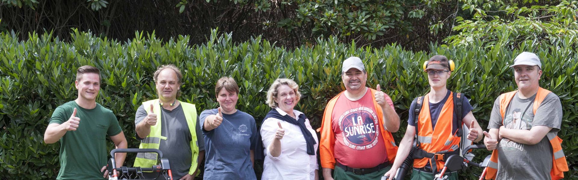 Gartenbau-Team der Elbe-Werkstätten mit Rasenmähern.