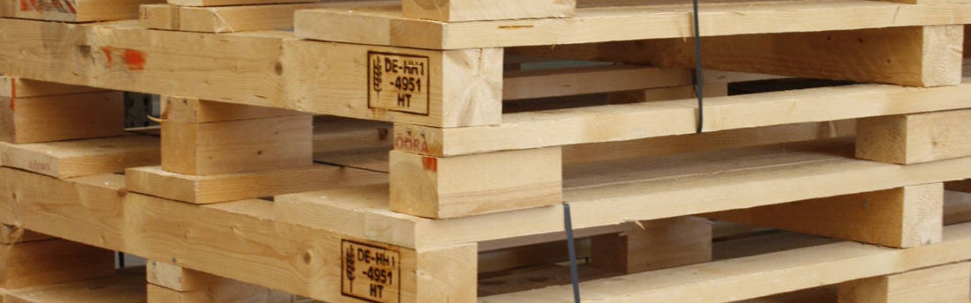 Übereinandergestapelte Holzpaletten für die Weiterverarbeitung in den Werkstätten.